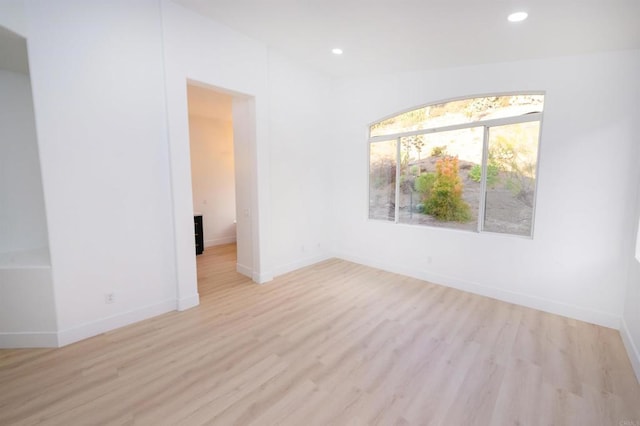 unfurnished room with light wood-type flooring, baseboards, and recessed lighting