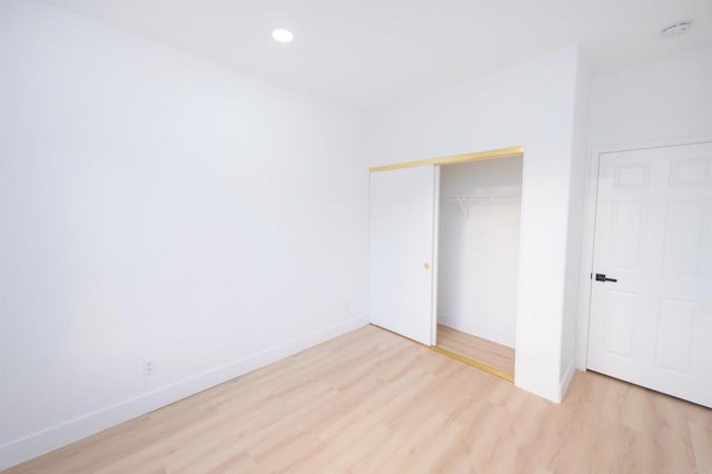 unfurnished bedroom with recessed lighting, a closet, baseboards, and light wood finished floors