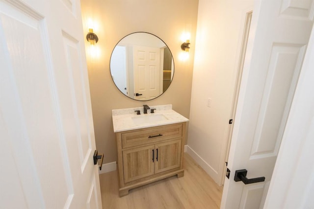 bathroom with vanity, baseboards, and wood finished floors