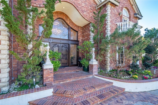 view of exterior entry featuring brick siding