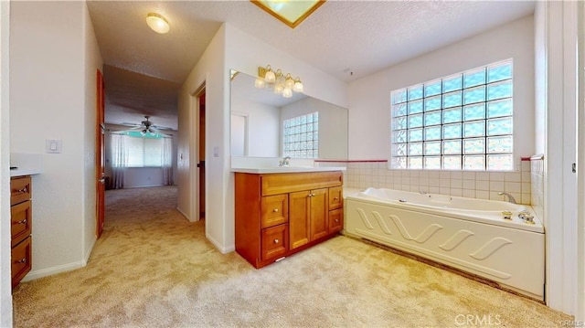 bathroom featuring carpet floors, vanity, a textured ceiling, and a bath