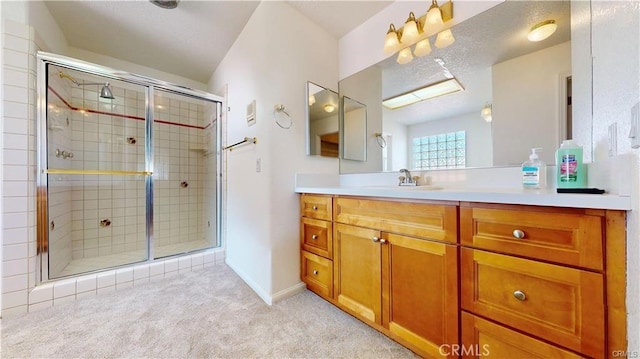 full bathroom featuring a shower stall, baseboards, and vanity