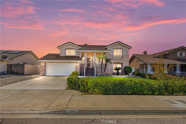 view of front of property with a garage, concrete driveway, fence, and stucco siding