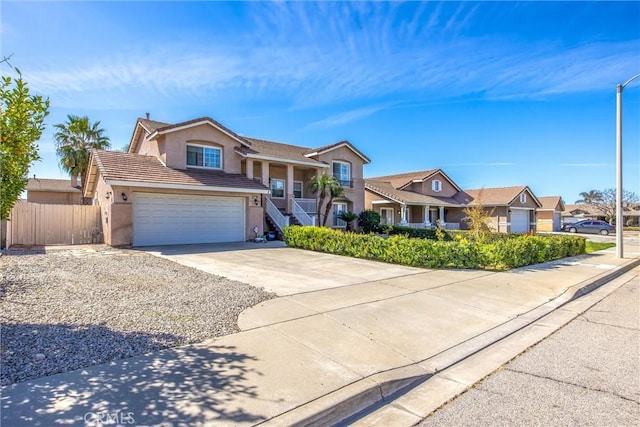 view of front of home with a tile roof, stucco siding, fence, a residential view, and driveway