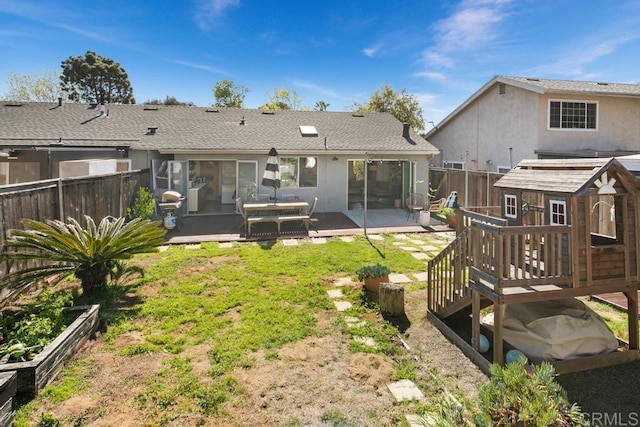 back of property featuring a fenced backyard, a shingled roof, and stucco siding