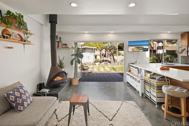 interior space with finished concrete flooring, a wood stove, and recessed lighting