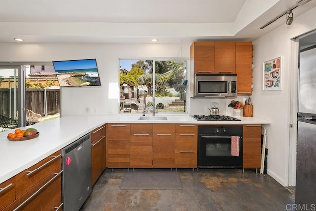 kitchen with appliances with stainless steel finishes, light countertops, brown cabinetry, and concrete floors