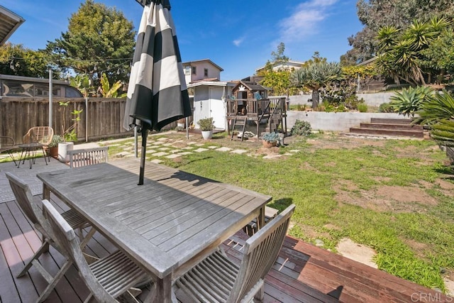 wooden deck with a yard, an outdoor structure, and fence