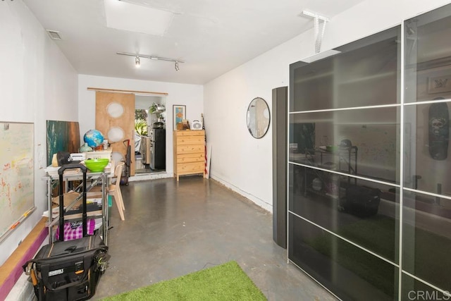 misc room with a skylight, concrete floors, and visible vents