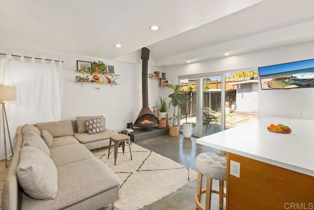 living room featuring a wood stove, concrete flooring, and recessed lighting