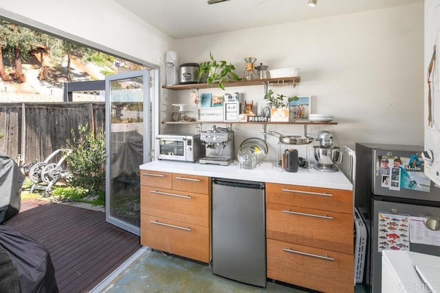 bar with concrete flooring and appliances with stainless steel finishes