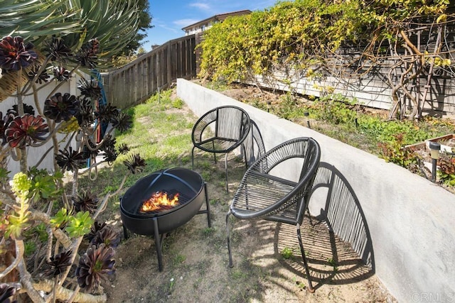 exterior space with an outdoor fire pit and a fenced backyard