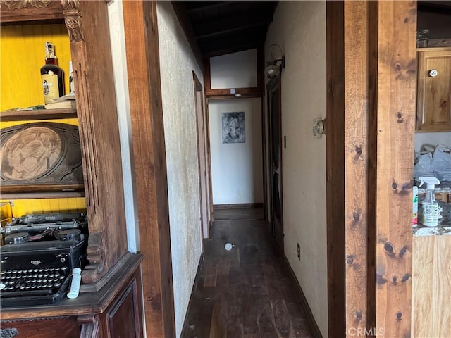 hall with dark wood-type flooring and baseboards