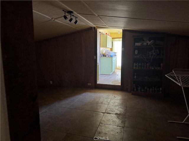 interior space featuring vaulted ceiling and wood walls