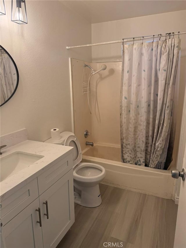 full bathroom featuring toilet, shower / tub combo, wood finished floors, and vanity