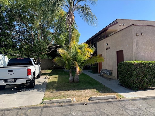 view of side of home with a yard and stucco siding