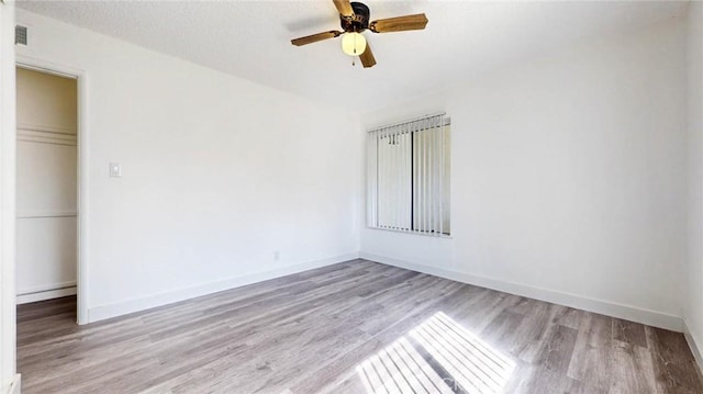 unfurnished room with visible vents, baseboards, and wood finished floors