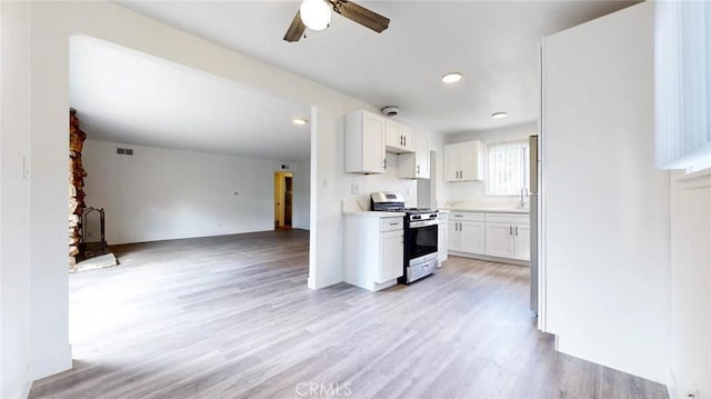 kitchen with visible vents, light wood-style floors, open floor plan, white cabinets, and stainless steel gas range