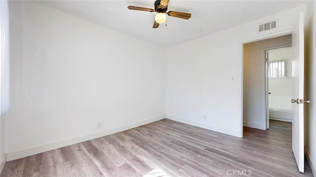 empty room featuring baseboards, visible vents, ceiling fan, and wood finished floors