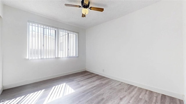 unfurnished room featuring a ceiling fan, baseboards, a textured ceiling, and wood finished floors