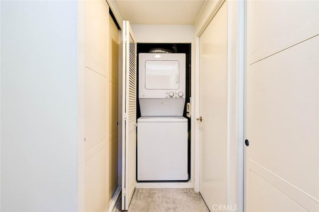 laundry area featuring laundry area, stacked washing maching and dryer, and carpet flooring