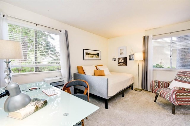 bedroom with light colored carpet and multiple windows