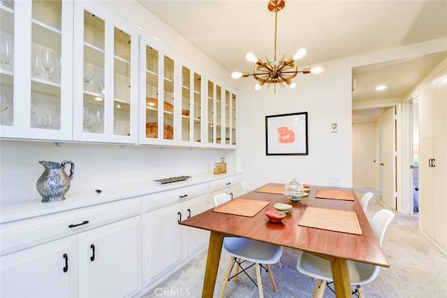 dining space with a chandelier and light colored carpet