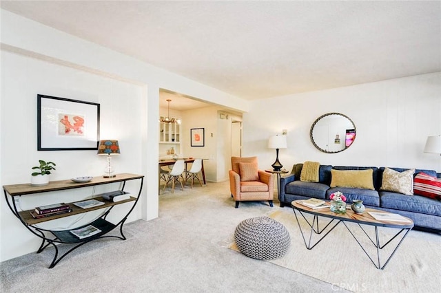 carpeted living area featuring a notable chandelier