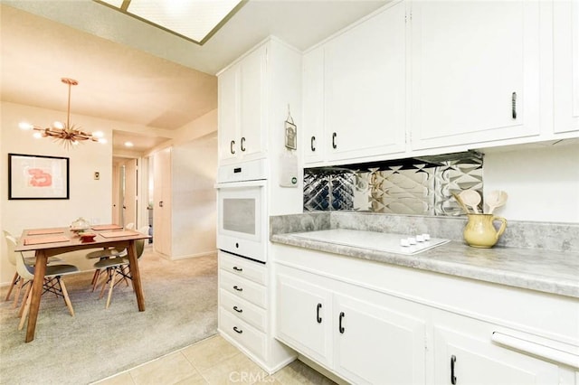 kitchen with white cabinets, light countertops, and oven