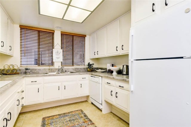 kitchen with light tile patterned floors, light countertops, white cabinets, a sink, and white appliances