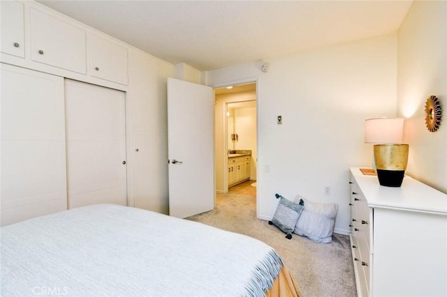 bedroom featuring light carpet, a closet, and baseboards