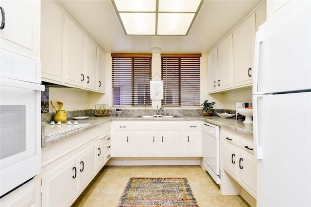 kitchen featuring white appliances, light tile patterned floors, light countertops, and a sink