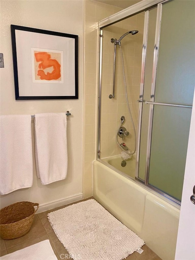 bathroom with bath / shower combo with glass door and tile patterned floors