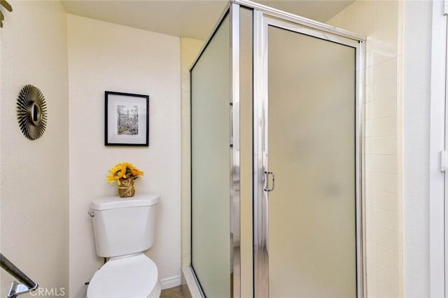 bathroom featuring toilet and a stall shower