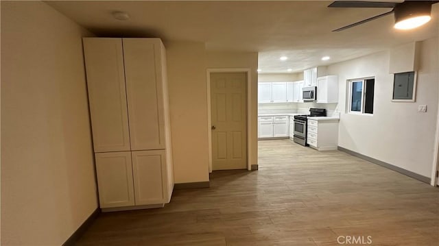 interior space with recessed lighting, light wood-type flooring, electric panel, and baseboards