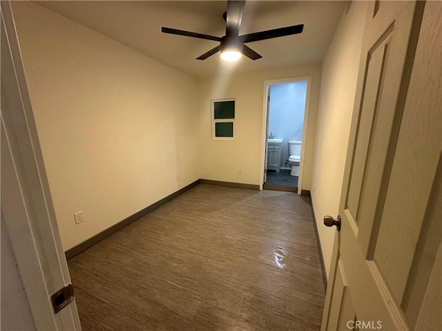 unfurnished bedroom with ensuite bathroom, ceiling fan, baseboards, and wood finished floors