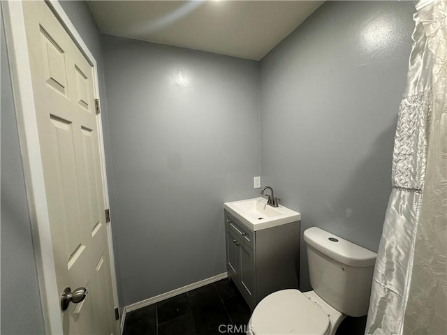 bathroom featuring toilet, tile patterned flooring, baseboards, and vanity