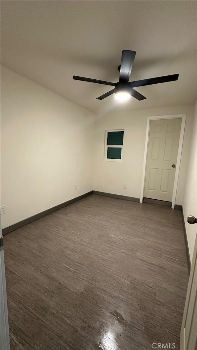 spare room featuring dark wood-style floors, baseboards, and a ceiling fan