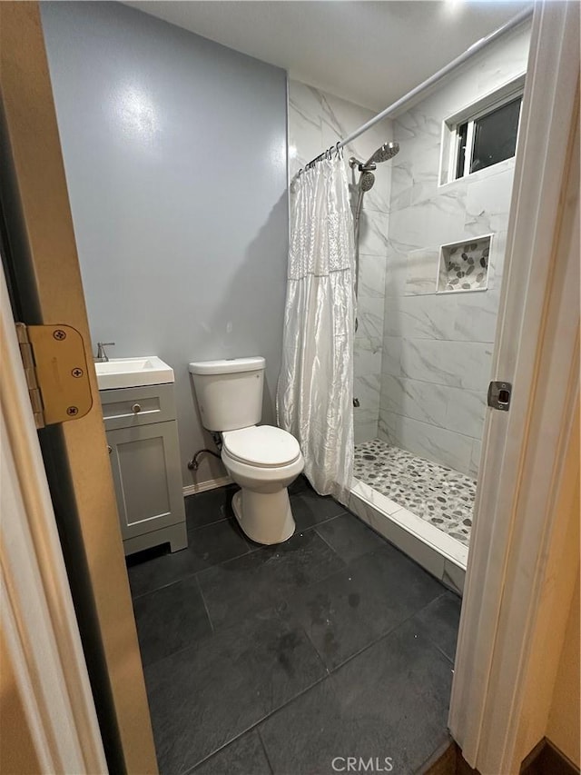 full bath with a stall shower, vanity, and toilet