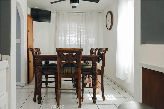 dining room with light tile patterned flooring, baseboards, and a ceiling fan