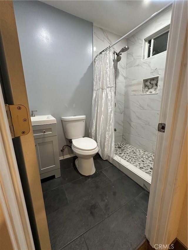 bathroom featuring a shower stall, vanity, and toilet