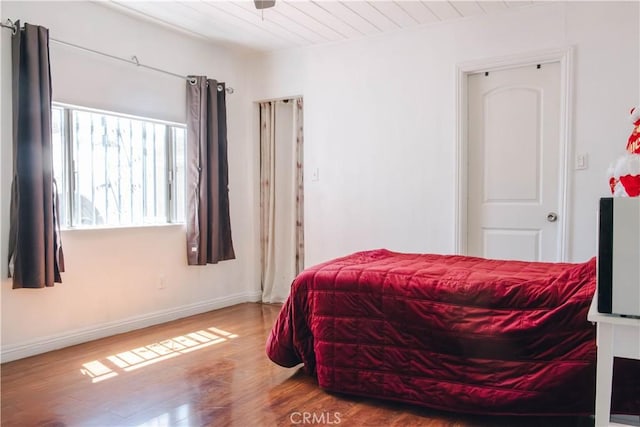 bedroom featuring baseboards and wood finished floors