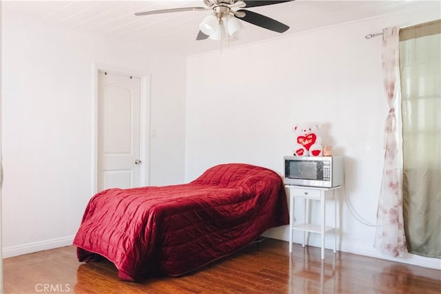 bedroom with baseboards, ceiling fan, and wood finished floors