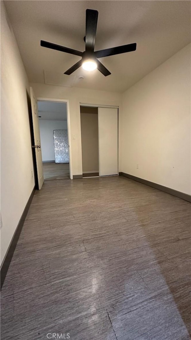 unfurnished bedroom featuring a closet, baseboards, and a ceiling fan