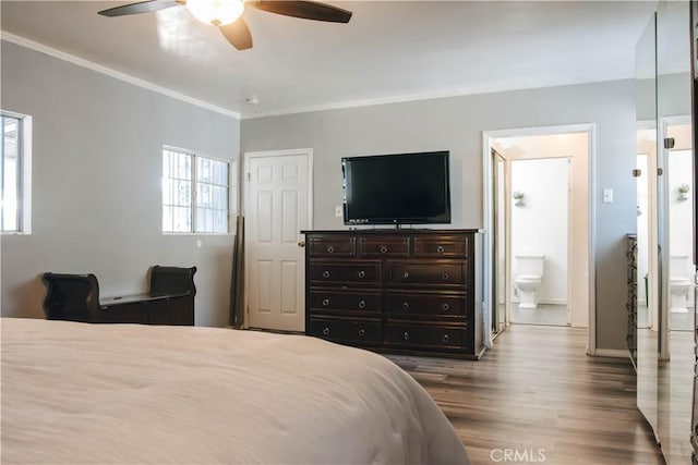 bedroom featuring ceiling fan, crown molding, connected bathroom, and dark wood finished floors