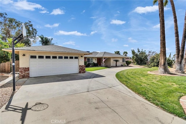 view of front of house featuring a garage, a front yard, concrete driveway, and stucco siding