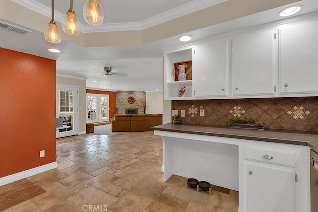 kitchen featuring dark countertops, ceiling fan, ornamental molding, and backsplash