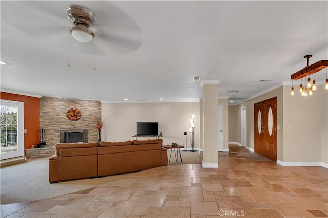 living room featuring stone tile floors, visible vents, baseboards, crown molding, and a stone fireplace