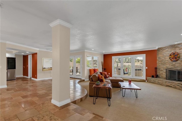 living room with baseboards, a stone fireplace, french doors, and crown molding