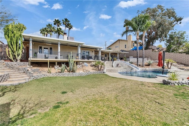 rear view of house with a fenced in pool, a lawn, ceiling fan, and a patio